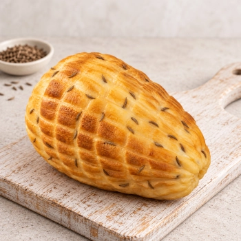 Wędzony ser podpuszczkowy z kminkiem 350g na jasnej drewnianej desce